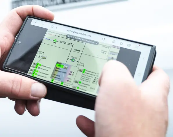 Håller i telefon som visar mätningar